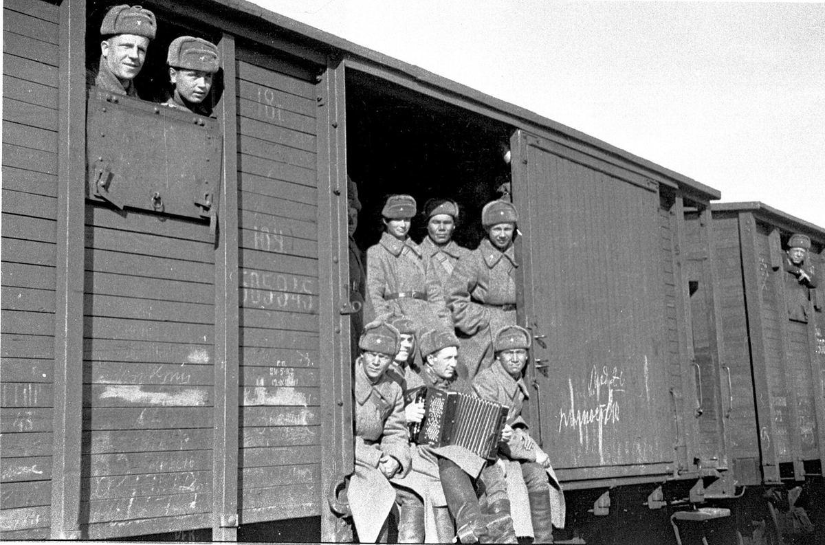 Солдаты из сибирских областей едут в теплушке на защиту Москвы, октябрь 1941 года. Где именно сделан снимок, не указано.