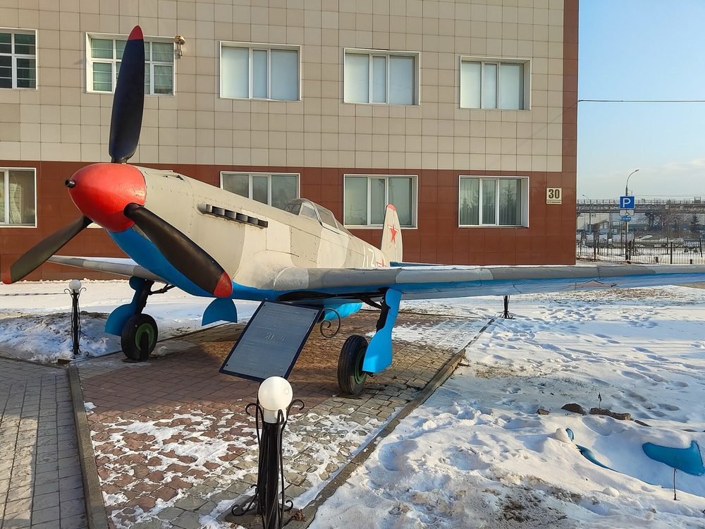 Копия истребителя Як-9 на постаменте перед зданием колледжа