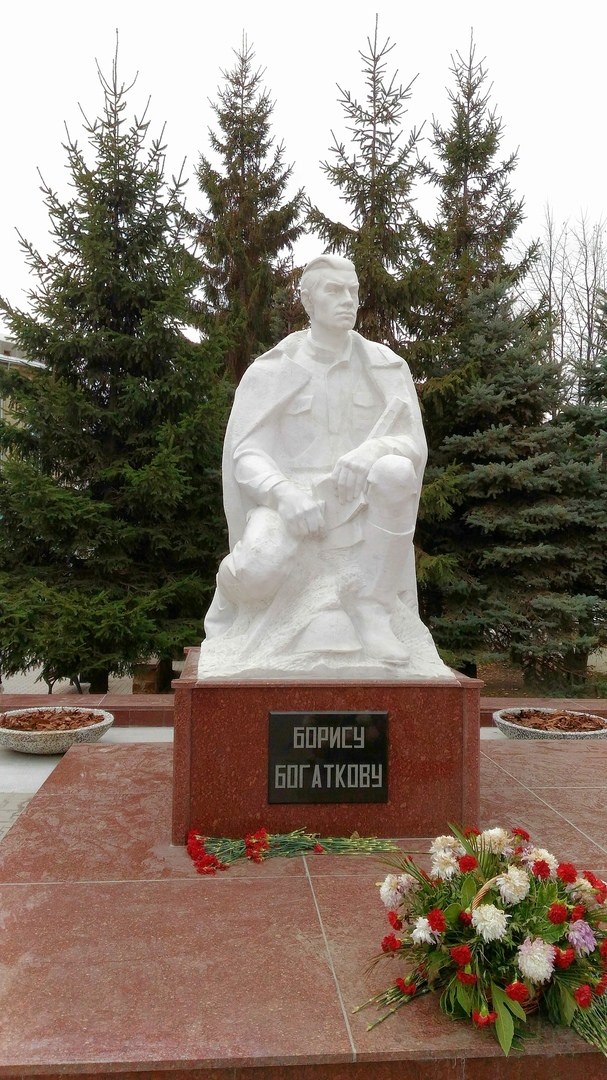 Белая скульптура поэта в шинели на красном гранитном постаменте с надписью «Борису Богаткову»